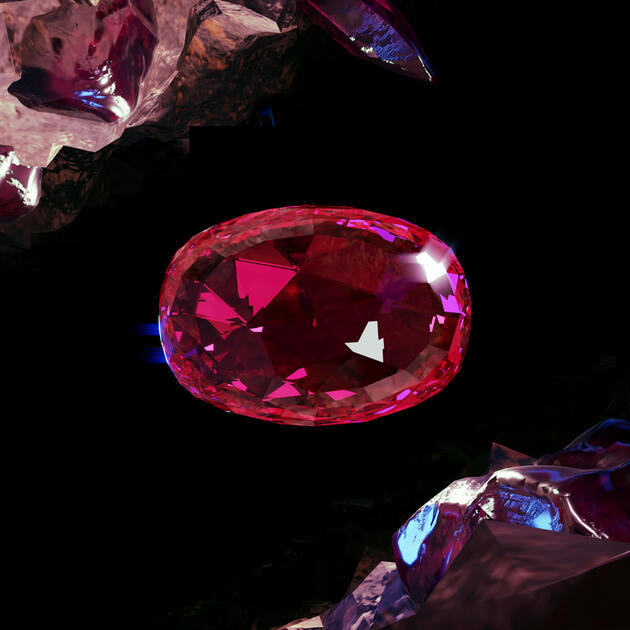 An oval cut, pink-red ruby on a black background. In the top left and bottom right corners are chunks of uncut ruby gemstone embedded in stone.